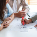 Couple reviewing papers and property maps for settlement over multiple properties