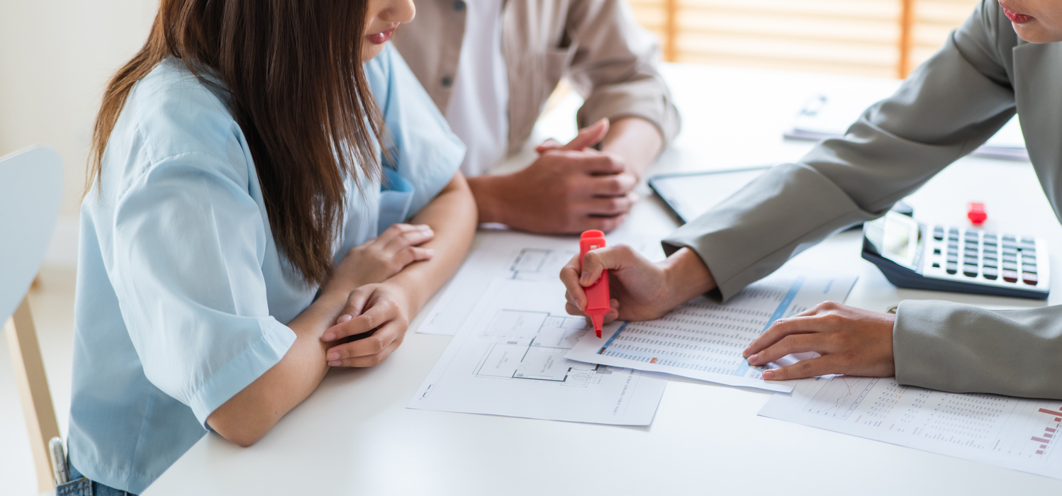 Couple reviewing papers and property maps for settlement over multiple properties