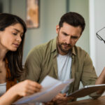 Property buyers discussing settlement delay issues with conveyancing lawyer in NSW