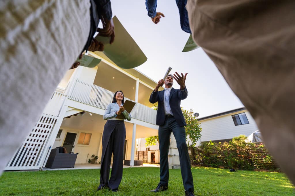 Real estate auctioneer holding a gavel at a residential property auction in New South Wales.